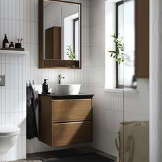 a bathroom with a sink, mirror and toilet in it's center area next to a window