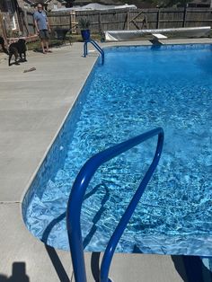 an empty swimming pool with no people in it and a dog standing on the side