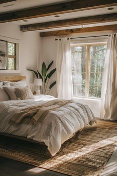 a bedroom with a bed, window and rug in front of the bed is shown