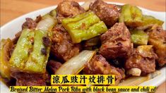 a white plate topped with meat and veggies on top of a wooden table