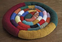 a multicolored knitted object sitting on top of a wooden table