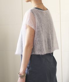 a woman standing in front of a white wall