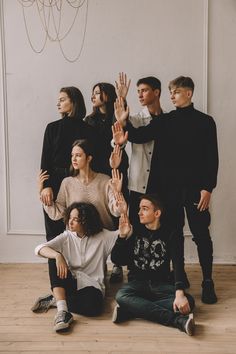 a group of people sitting on the floor with their hands up in front of them