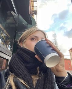 a woman drinking out of a coffee cup