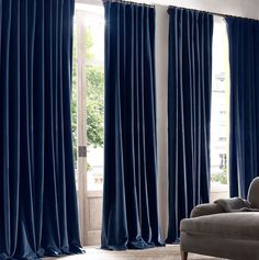 a living room filled with furniture and blue curtains