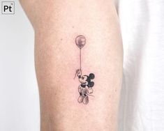 a person with a small tattoo on their leg that has a balloon attached to it