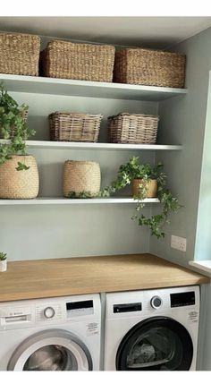 a washer and dryer in a laundry room with baskets on the shelves above