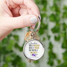 a person holding a keychain with a quote on it