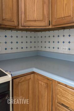 the corner of a kitchen with wooden cabinets and blue counter tops is pictured in this image