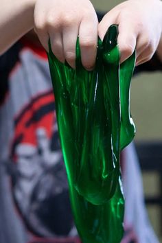 a young boy holding a green object in his hands