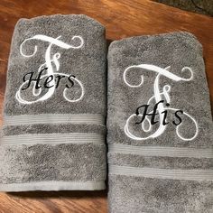 two gray towels with the letters t and h on them sitting next to each other