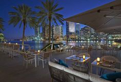 an outdoor dining area overlooking the water at night