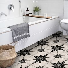 a bathroom with black and white tiles on the floor