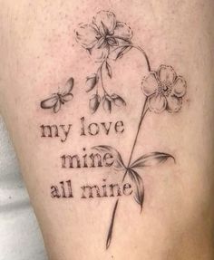 a woman's thigh with flowers and the words my love mine all mine on it