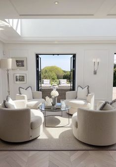 a living room filled with white furniture and lots of windows