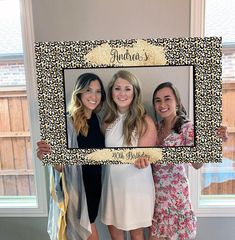 three women posing for a photo in front of a leopard print frame