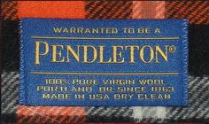 a label on the back of a plaid shirt that is blue, orange and black