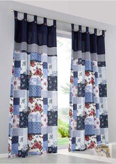 blue and white patchwork curtains hanging in front of a window