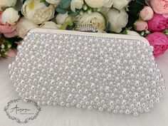 This elegant bridal clutch features silver trim, attachable chain and large enough for your phone. Complete your list of must-have wedding accessories with the ultimate bridal accessory to finish off your look and storing your wedding day essentials. Details： Inside Material: Satin Size: 9.6*2*5.5inch/24.5*5*14cm Come with a removable short chain（37cm） and a long chain（116cm) and a pearl chain that can be used as shoulder bag or crossbody bag or as clutch. Request a cancellation within 24 hours White Pearl Evening Bag For Party, White Pearl Embellished Bridal Accessories For Party, Pearl White Clutch For Parties, Glamorous Pearl Evening Bag For Wedding, Formal Pearl White Evening Bag, Formal Bridal Accessories In Pearl White, Glamorous White Clutch For Wedding, Elegant Pearl Bridal Accessories For Party, Pearl Evening Bag With Pearl Handle For Wedding Guest