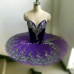 a mannequin dressed in a purple and silver tutu with sequins