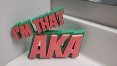 i'm that aka spelled out in pink and green letters on a white surface