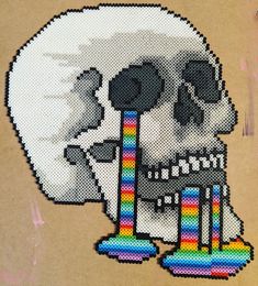 a cross stitch skull with a rainbow colored tube sticking out of it's mouth