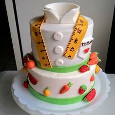 a three tiered cake with fruit and measuring tape on the top is decorated in fondant