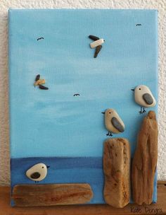 three birds sitting on top of a piece of wood next to the ocean with seagulls flying around