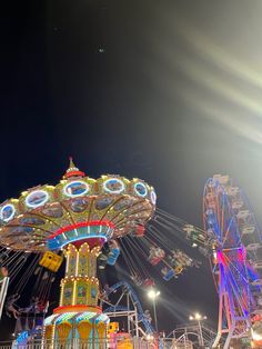 an amusement park at night with lights and rides