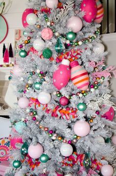 a white christmas tree with pink and green ornaments