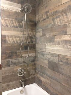 a bathtub with a shower head and hand held faucet in the corner