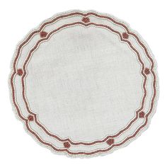 a white and red place mat with an embroidered border on the edge, in front of a