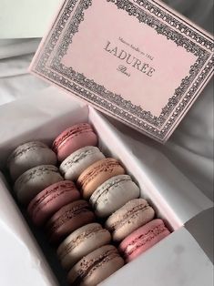 a box filled with macaroons sitting on top of a bed