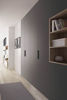 an empty room with bookshelves and pictures on the wall next to a rug