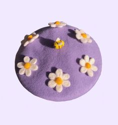 a purple cake with white and yellow flowers on it