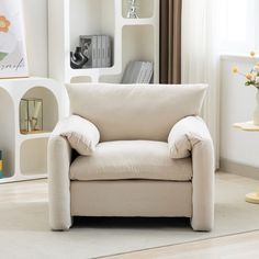 a living room with a white chair and bookshelf in it's corner