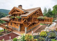 a large wooden house surrounded by greenery and trees