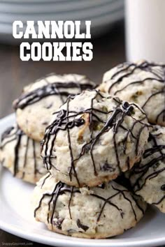 cookies with chocolate drizzled on them sitting on a plate next to a cup