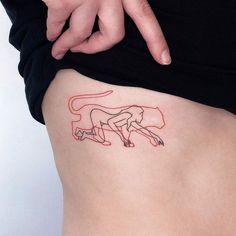 a woman's thigh with a red line drawing of a running cat on it