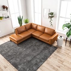 a brown leather sectional sofa sitting on top of a gray rug