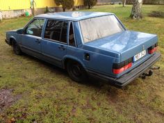 an old blue station wagon parked in the grass