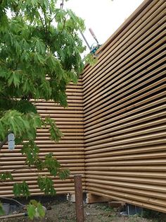 a large wooden fence next to a tree