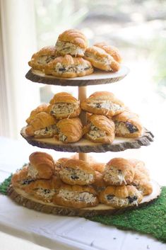 three tiered trays filled with pastries sitting on top of a green mat