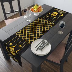 the table is decorated with yellow and black designs on it, along with silverware