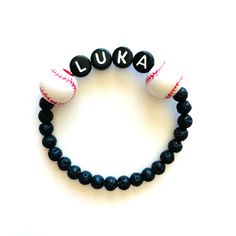 Sports themed name bracelets are great gifts for your favorite player or for sports themed bday party favors! Choose baseball, basketball or soccer beads, add a name, and we'll do the rest! The lava beads are 4mm. Please check all selections and spelling prior to check out. Our custom bracelets are made to order so all sales are final. The bracelets are beautifully packaged and ready to gift. Receipts are never included. Roll, don't pull. To avoid excess stretching please roll the bracelet on an Personalized White Wristband For Team Events, Customizable Novelty Bracelets For Birthdays, Personalized White Wristbands For Team Events, Novelty Bracelets With Letter Beads For Birthday, Novelty Birthday Bracelets With Letter Beads, Game Day Black Wristband With Letter Beads, Adjustable Black Team Spirit Jewelry, Customizable White Sports Bracelets, Personalized Beaded Bracelets For Birthday And Father's Day