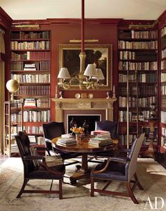 a dining room table surrounded by chairs and bookshelves