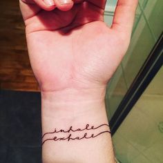 a person's wrist with a small tattoo on it