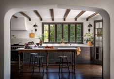 a kitchen with an archway leading into the dining room and breakfast nooks on either side