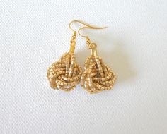 Super fancy light gold knot earrings. Matching necklace sold separately.Measures aprox. 1" not including the hook. ❤ SIZESIf you wish, this item can be made in a different size. The smallest we can make them is 0.5 inch, also we can make them 1 inch, 1.5 inches, and 2 inches. Depending on the size the shape of the knot may vary. Please contact us to inquire. ❤ PROCESSING AND SHIPPINGMost orders are made and shipped out in one business day. Please check delivery timeframes for your location on th Gold Beaded Earrings With Ear Wire For Party, Elegant Gold Wire Wrapped Beaded Earrings, Gold Beaded Earrings, Seed Bead Earring, Teal Bracelet, Gold Knot Earrings, Earrings Matching, Fancy Light, Gold Bead Earrings