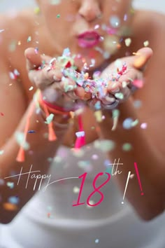 a woman holding confetti in her hands with the words happy 18th on it